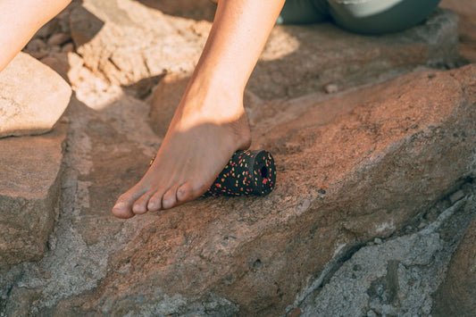 Bare foot rolling on a foot massage roller for fast pain relief